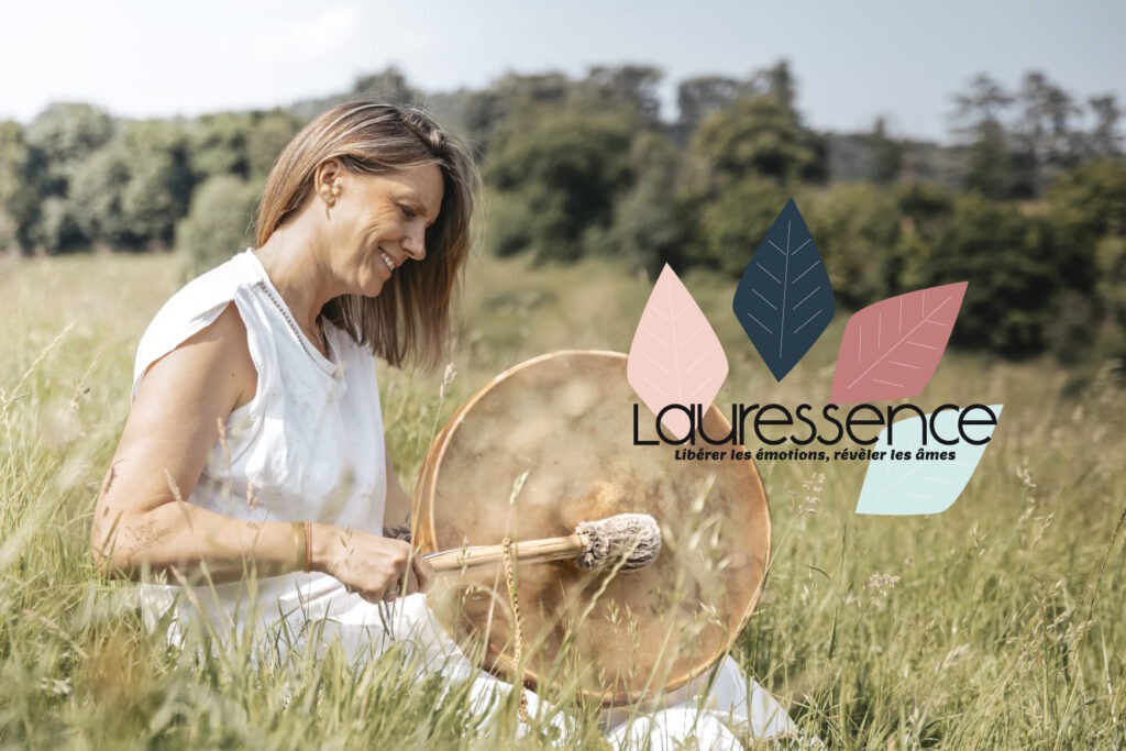 Laurence assise au milieu d'une belle prairie où elle peut laisser chanter son tambour et son logo Lauressence